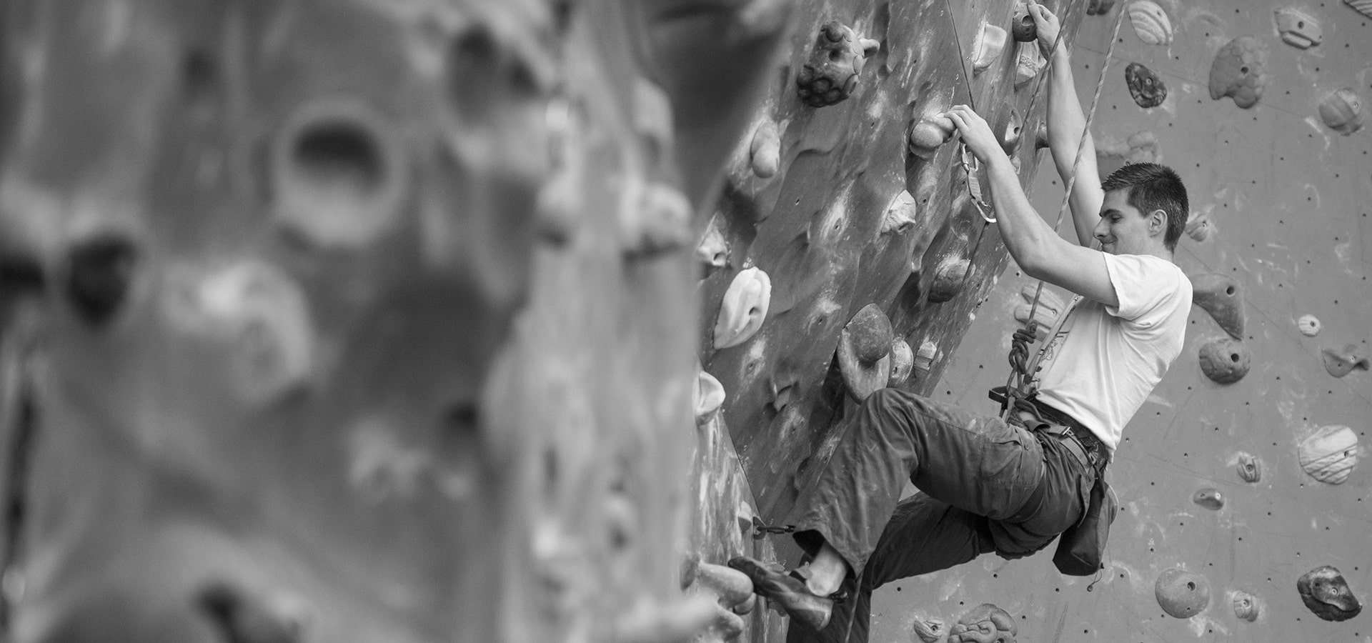 Man rock climbing indoors-min